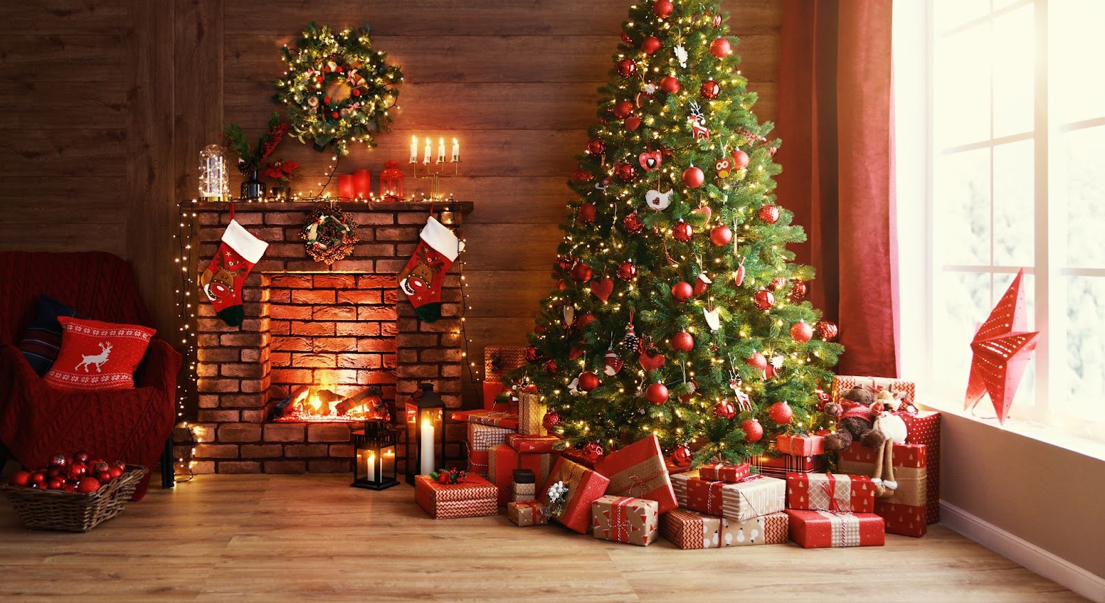 A beautifully decorated Christmas tree stands beside a cozy fireplace in a living room, highlighting seasonal warmth and joy.