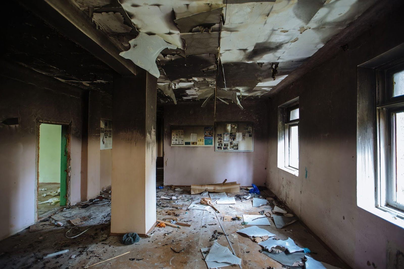 A cluttered room filled with debris and shattered windows, reflecting neglect and disarray