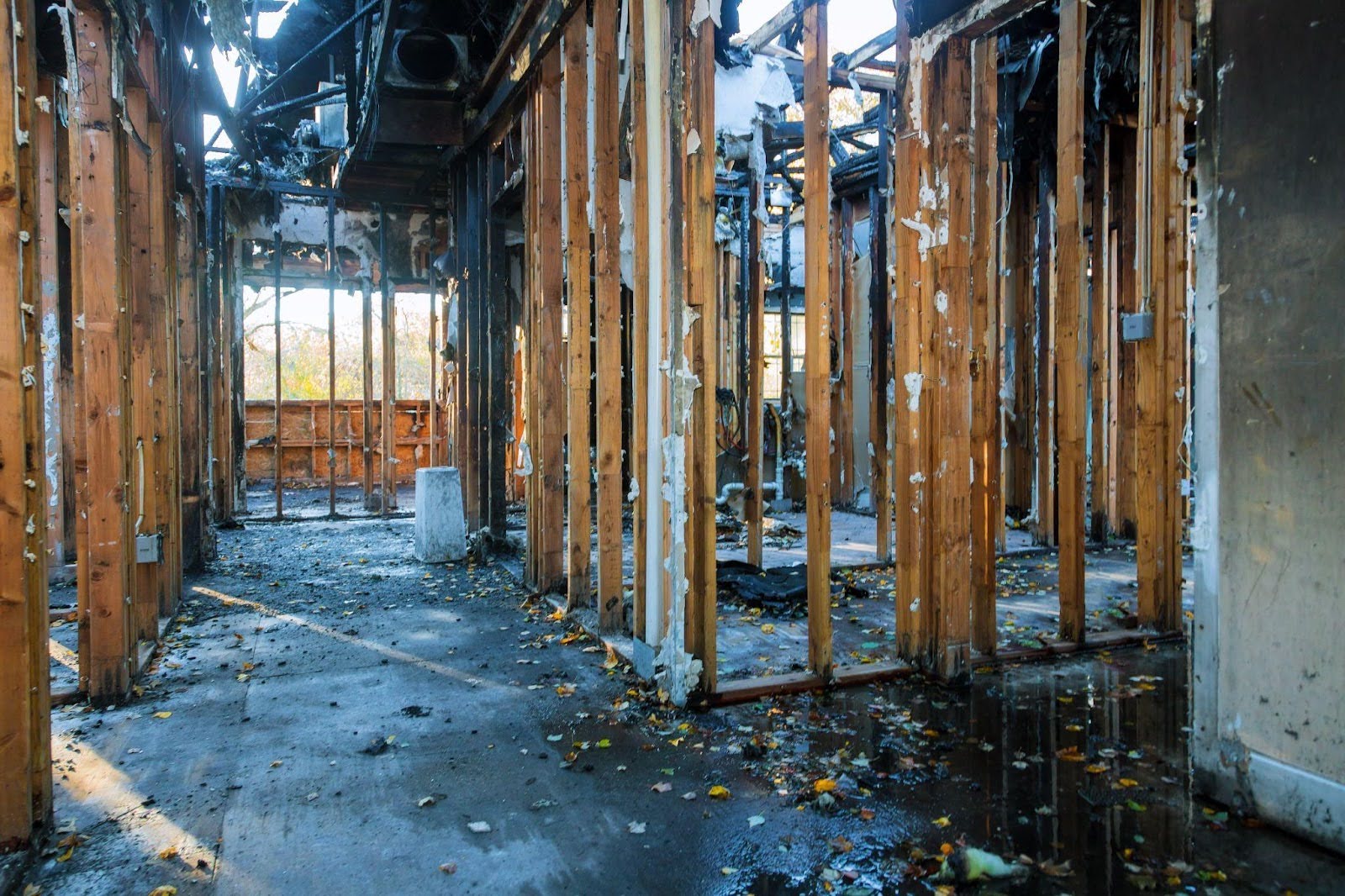 A fire-damaged room with visible wood framing and empty windows highlighting blaze aftermath