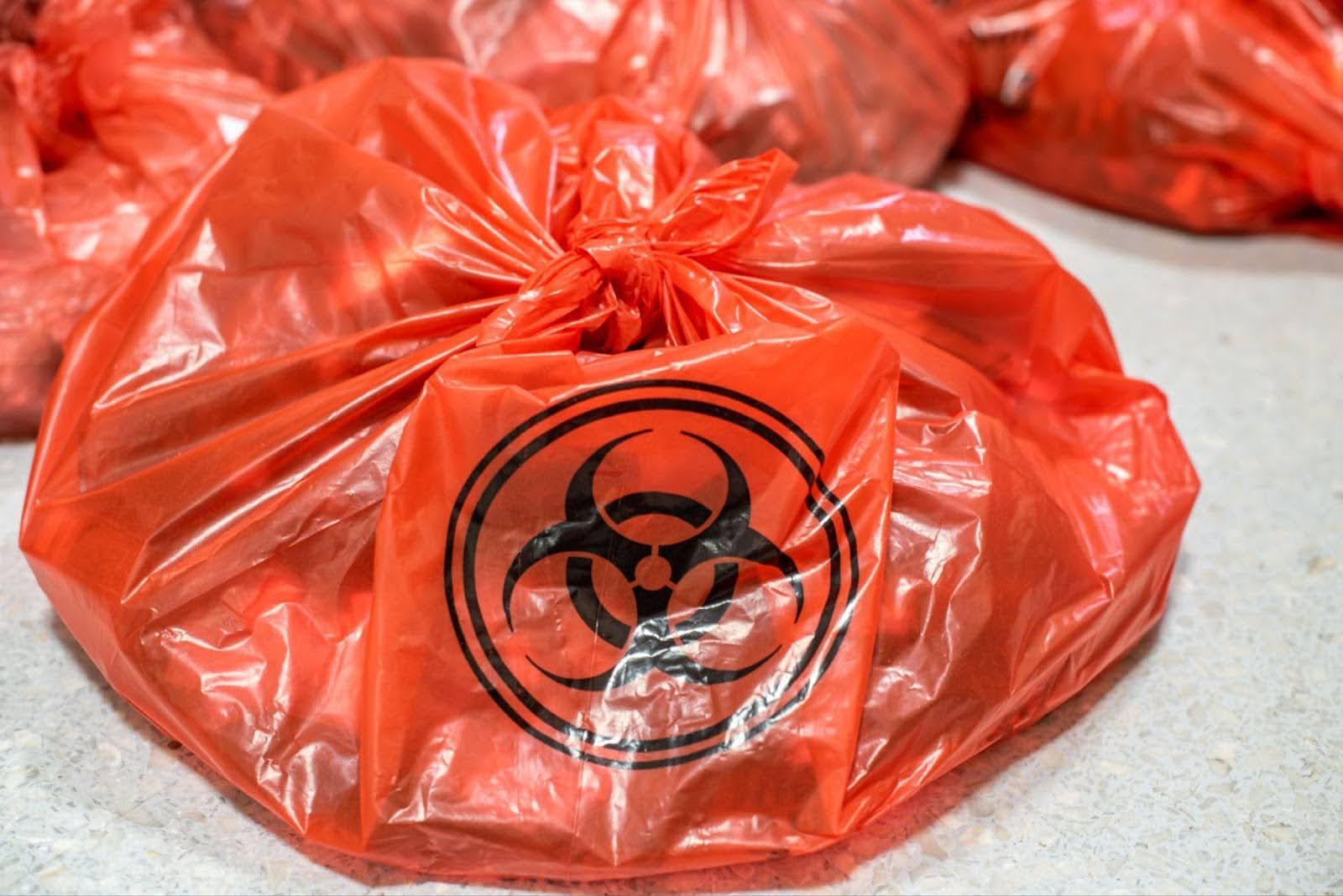 A bag of biohazardous waste on the floor indicating health risks and the need for proper disposal