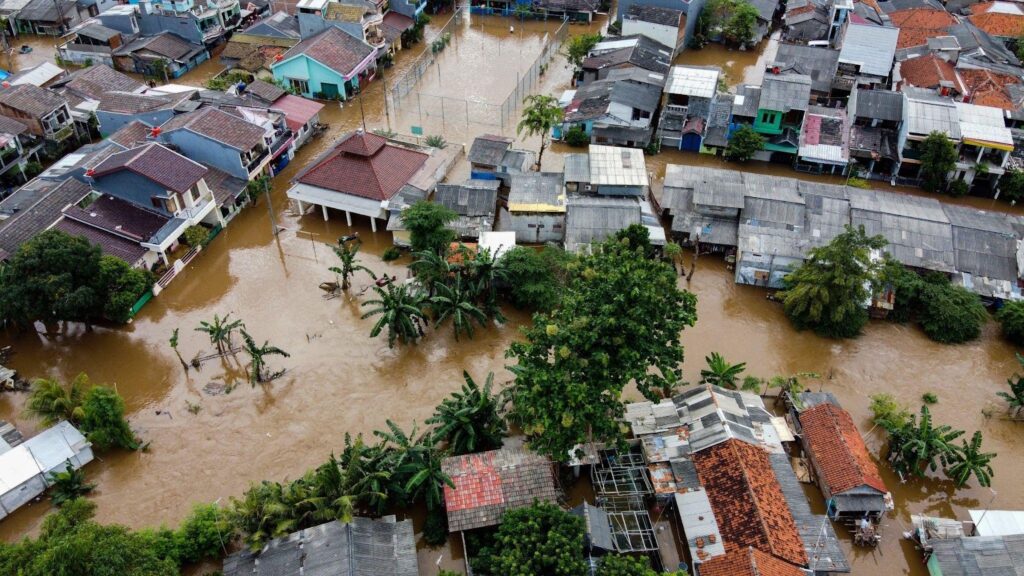 Flooded streets in Jakarta Indonesia on July 26 2015 showing submerged vehicles and people wading through water
