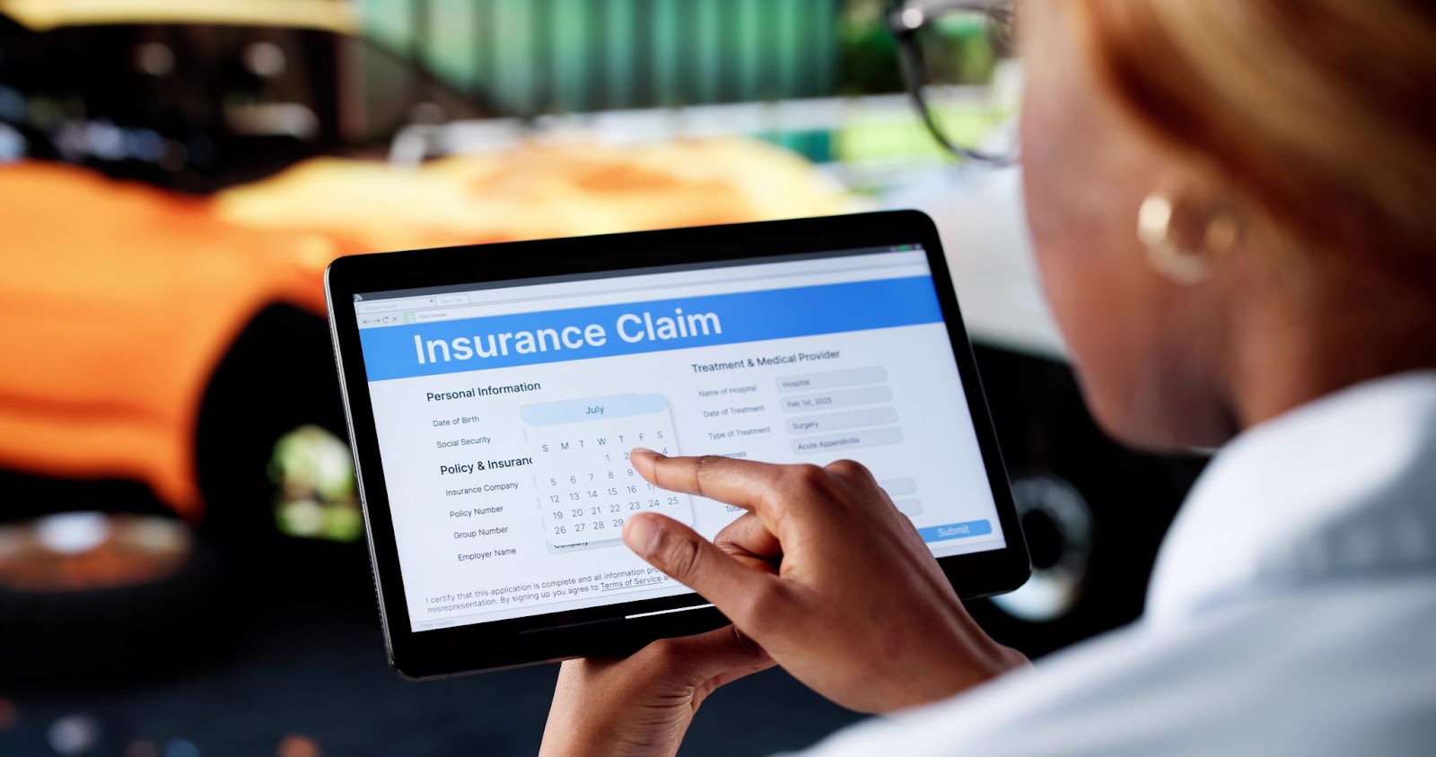 Person filling out online insurance claim form on tablet, pointing at calendar date. Screen shows personal info, policy details, and treatment fields.