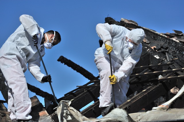 Two men in protective gear working on a house, representing restoration services in Utah.