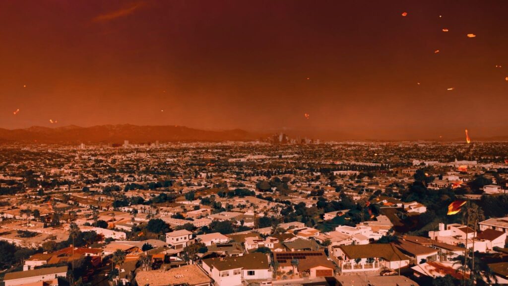 A sprawling city glows beneath an ominous orange smoke filled sky with distant mountains